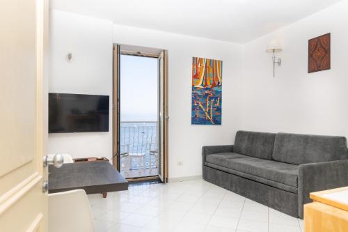 a living room with a couch and a television at Coltur Suites in Sorrento