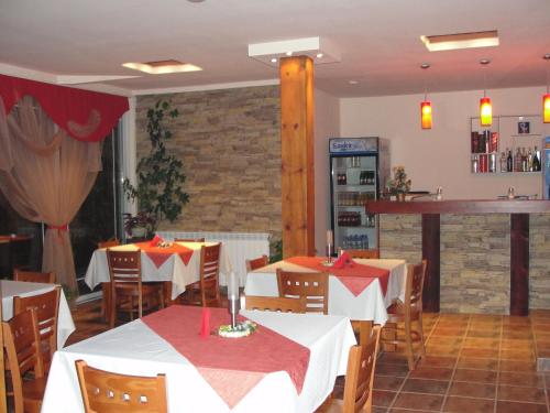 バンスコにあるZasheva Kushta Guesthouseのテーブルと椅子が備わるレストラン