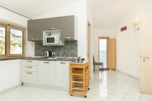 a kitchen with a sink and a microwave at Coltur Suites in Sorrento