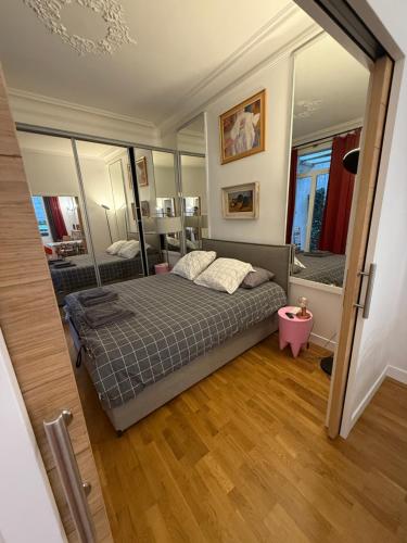 une chambre avec un lit et un grand miroir dans l'établissement Charming 2 Bedroom with Huge Private Terrace, à Paris