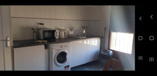 une cuisine avec un lave-linge et un micro-ondes dans l'établissement appartement lumineux sur le vieux port, à Marseille