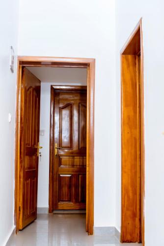 an open wooden door in a white room at Martin Aviator Apartment in Kigali