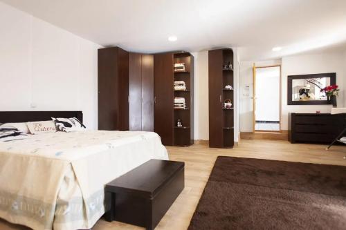 a bedroom with a large bed and a black stool at Charming Villa in Linares with Private Pool in Jaén