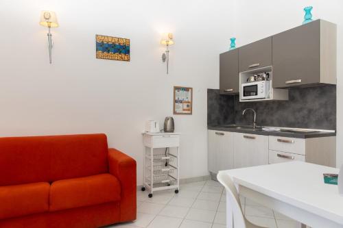 a kitchen with a red couch and a kitchen gmaxwell gmaxwell gmaxwell gmaxwell gmaxwell at Coltur Suites in Sorrento