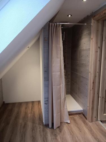 an attic room with a staircase with a curtain at NEU! Ferienwohnung Schwalbe in Grünow