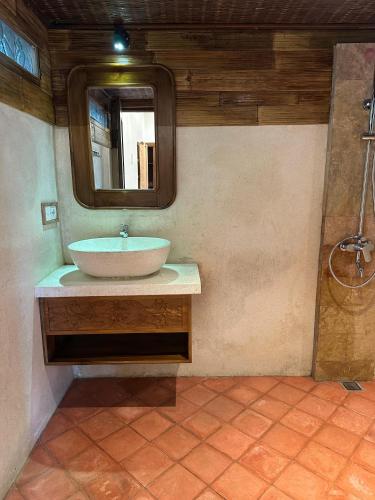 a bathroom with a sink and a mirror at Villa Karma Loka in Sidemen