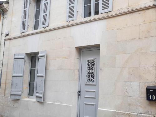 - un bâtiment avec une porte et deux fenêtres dans l'établissement Au numéro 10, à Jonzac