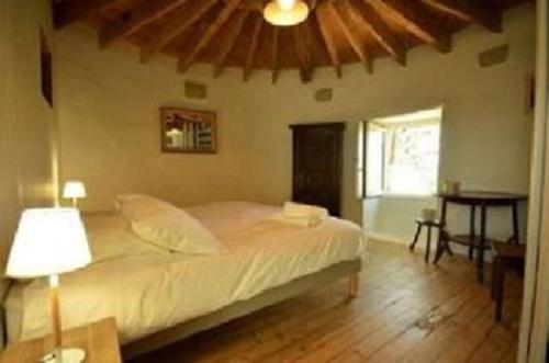 une chambre avec un lit, une table et une fenêtre dans l'établissement Le Moulin du Moustoir VUE SUR LE GOLFE, à Locmariaquer