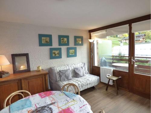 un salon avec un canapé et une table dans l'établissement T2 + coin nuit au pied des pistes, idéal pour 4 personnes - FR-1-458-187, au Grand-Bornand