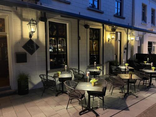un gruppo di tavoli e sedie all'esterno di un ristorante di Square Boutique Hotel & Brasserie a Venray