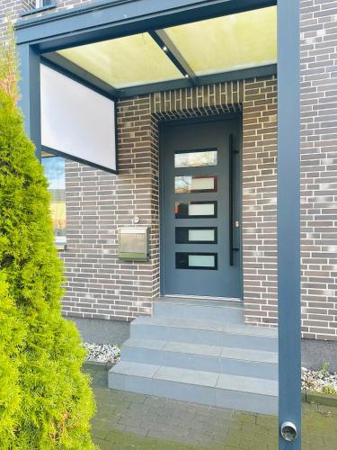 a front door of a brick house with a blue door at Chichi in Winsen Luhe