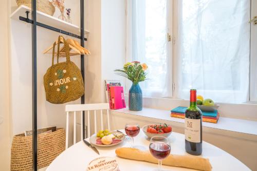 - une table avec une bouteille de vin et deux verres dans l'établissement Happy Stay Paris - Cosy Studio 5 min to Eiffel Tower, à Paris