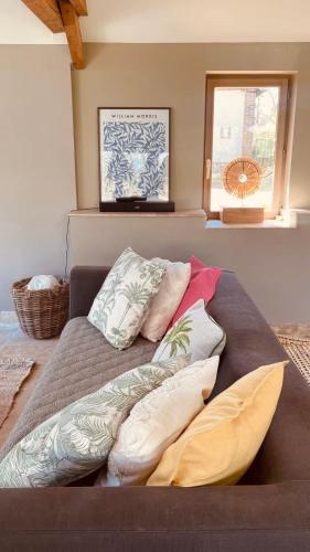 un lit avec des oreillers dessus dans une chambre dans l'établissement Cottage Normand avec sa grande piscine chauffée toute l année sur parc arboré et clos En plein coeur de la campagne adapté aux kids et Dog friendly, à Saint-Antonin-de-Sommaire