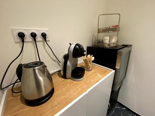 a kitchen counter with a tea kettle and a microwave at Studio Romance-Balnéo in Essert