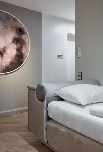 a bed in a room with a picture on the wall at Hotel Maria in Dębno Polskie