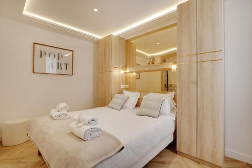 une chambre avec deux lits avec des serviettes dessus dans l'établissement Spacious Appartement au coeur de Paris FBMAR2, à Paris