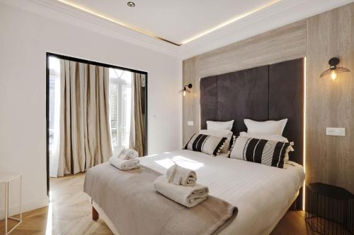 une chambre avec un grand lit avec des serviettes dessus dans l'établissement Spacious Appartement au coeur de Paris FBMAR2, à Paris