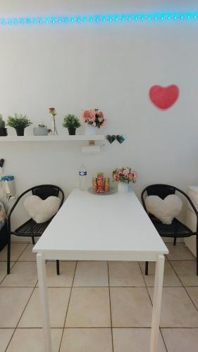 une table blanche dans une pièce avec deux chaises dans l'établissement centre villeOpéra,Gare st Lazare , cozy studio, à Paris