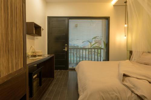 a bedroom with a bed and a sink and a window at Du De Homestay in Hoi An