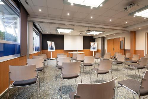 a conference room with chairs and a podium in it at Novotel Brussels Airport in Diegem