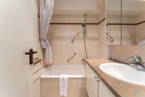 ein Badezimmer mit Badewanne und Waschbecken in der Unterkunft App met prachtige zeezichten op 1min van strand in Middelkerke