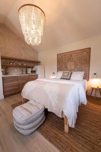 a bedroom with a large white bed and a chandelier at Seahorse Beach Bungalows in Fort Pierce