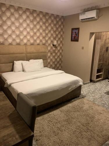 a bedroom with a large bed with a large headboard at Hotel Fountain Blu in Abeokuta