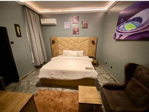 a bedroom with a bed and a desk and a chair at Hotel Fountain Blu in Abeokuta