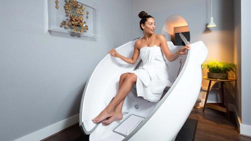 a woman sitting in a surfboard shaped bed with a laptop at The Laslett in London