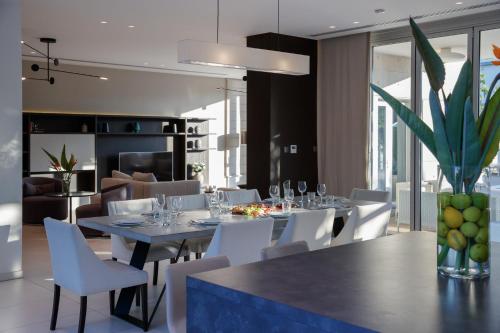 a dining room with a table and white chairs at Vivo Mare Beachfront Villas - Emerald in Ayia Napa