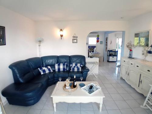 un salon avec un canapé en cuir noir et une table dans l'établissement Meschers sur Gironde - SEDUISANT COIN DE PARADIS avec sa PISCINE PRIVEE, à Meschers-sur-Gironde