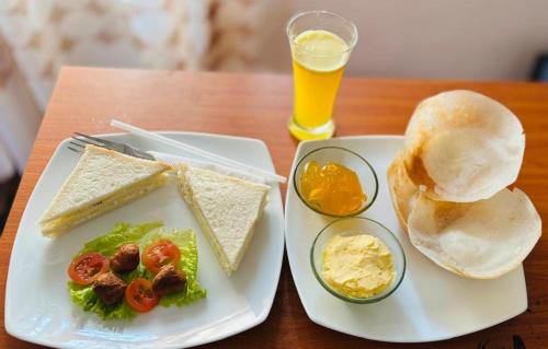 a plate of food with a sandwich and a drink at Mount Side Hiriketiya in Hiriketiya