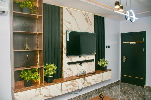 a living room with a flat screen tv on a wall at Hotel Fountain Blu in Abeokuta