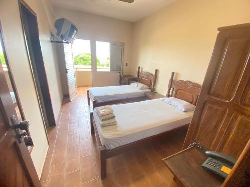 a room with two beds and a window at Abaeté Palace Hotel in Abaeté