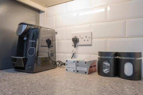 a room with a counter top with a tv and a charger at Cosy 4 bed with free parking, Chatham Town Centre in Chatham