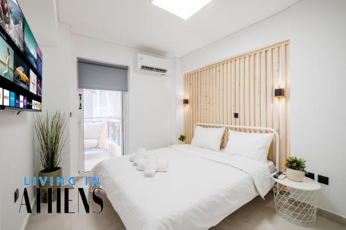 ein weißes Schlafzimmer mit einem großen Bett und einem TV in der Unterkunft Athenian Exclusive residence 4&2 ppl in Athen