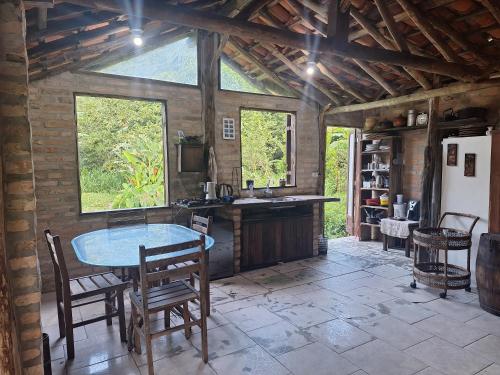 a kitchen with a table and chairs in a room at Casa rústica divertida in Florianópolis