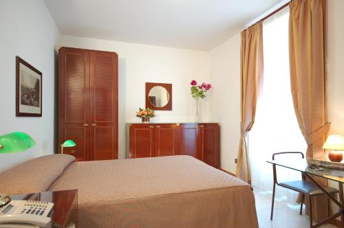 - une chambre avec un lit et un bureau avec un téléphone dans l'établissement Hotel Residence Vatican Suites, à Rome