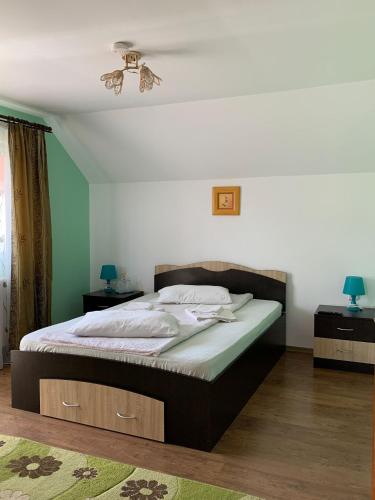 a bedroom with a bed and a ceiling fan at Floare de colt in Arefu