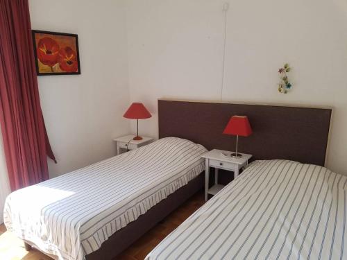 - 2 lits dans une chambre avec 2 lampes sur les tables dans l'établissement Villa Les Lauriers Blancs pour 6 personnes avec piscine privée et vue mer à La Londe-Les-Maures, à La Londe-les-Maures