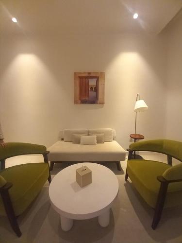 a room with a bed and two chairs and a table at Mina Hotel and Residences By The Torch in Doha
