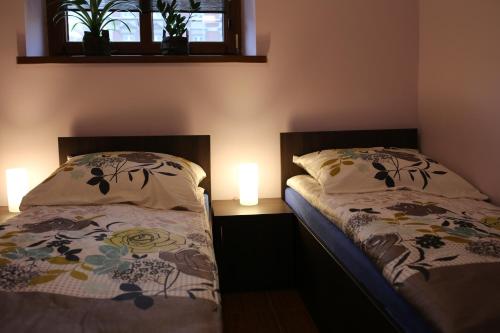 a bedroom with two beds and a window and two lamps at Noclegi Andersa in Wałbrzych