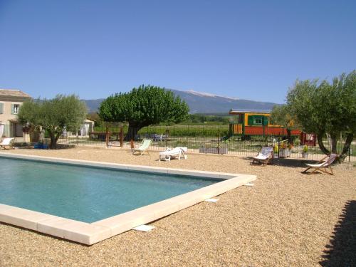 une piscine dans une cour avec des chaises et une maison dans l'établissement La Grange de Campaulise - Camping à la ferme - Hébergements - Mont Ventoux, à Mazan