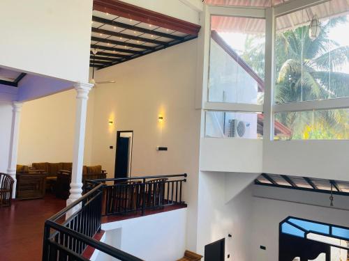 a living room with a staircase in a house at Rich Living Resort in Tangalle