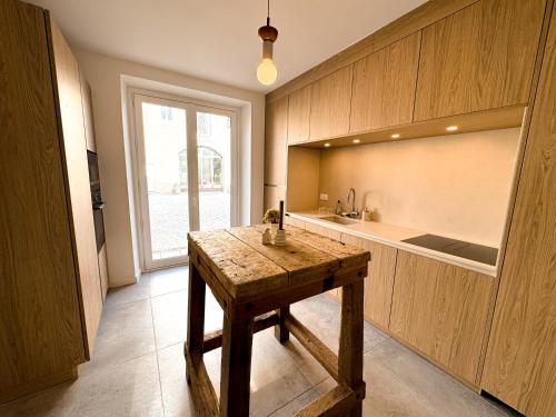 une cuisine avec une table en bois et une grande fenêtre dans l'établissement Maison Agane - accès canal du midi, piscine chauffée, à Pexiora