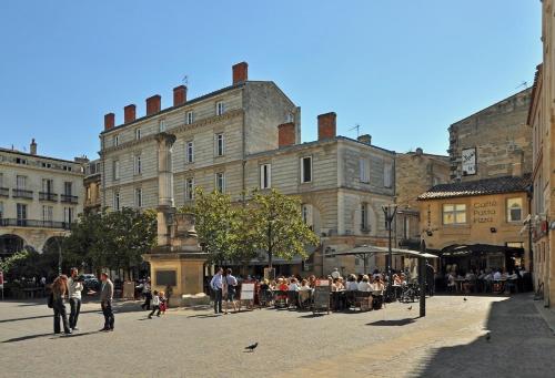 Un groupe de personnes debout dans une rue de la ville dans l'établissement Bordeaux hypercenter apartment, à Bordeaux