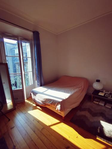 une chambre avec un lit et une grande fenêtre dans l'établissement Bordeaux hypercenter apartment, à Bordeaux