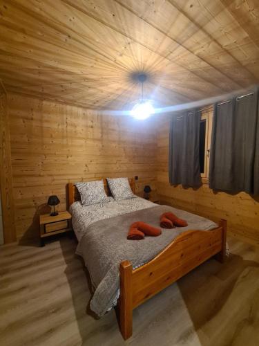 une chambre avec un lit dans une cabane en bois dans l'établissement loulettaz 2, au Grand-Bornand
