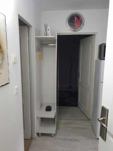 un pasillo con una puerta y un reloj en la pared en Garsoniera Samoilă, en Petroşani