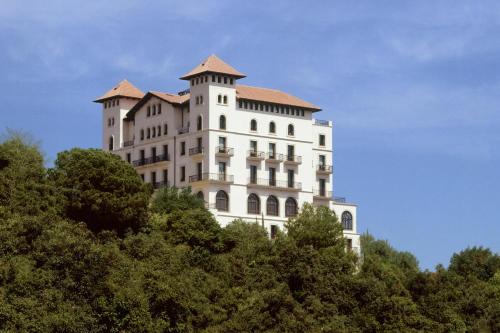 a tall white building on top of some trees at METT Barcelona GL - A Leading Hotel of the World in Barcelona